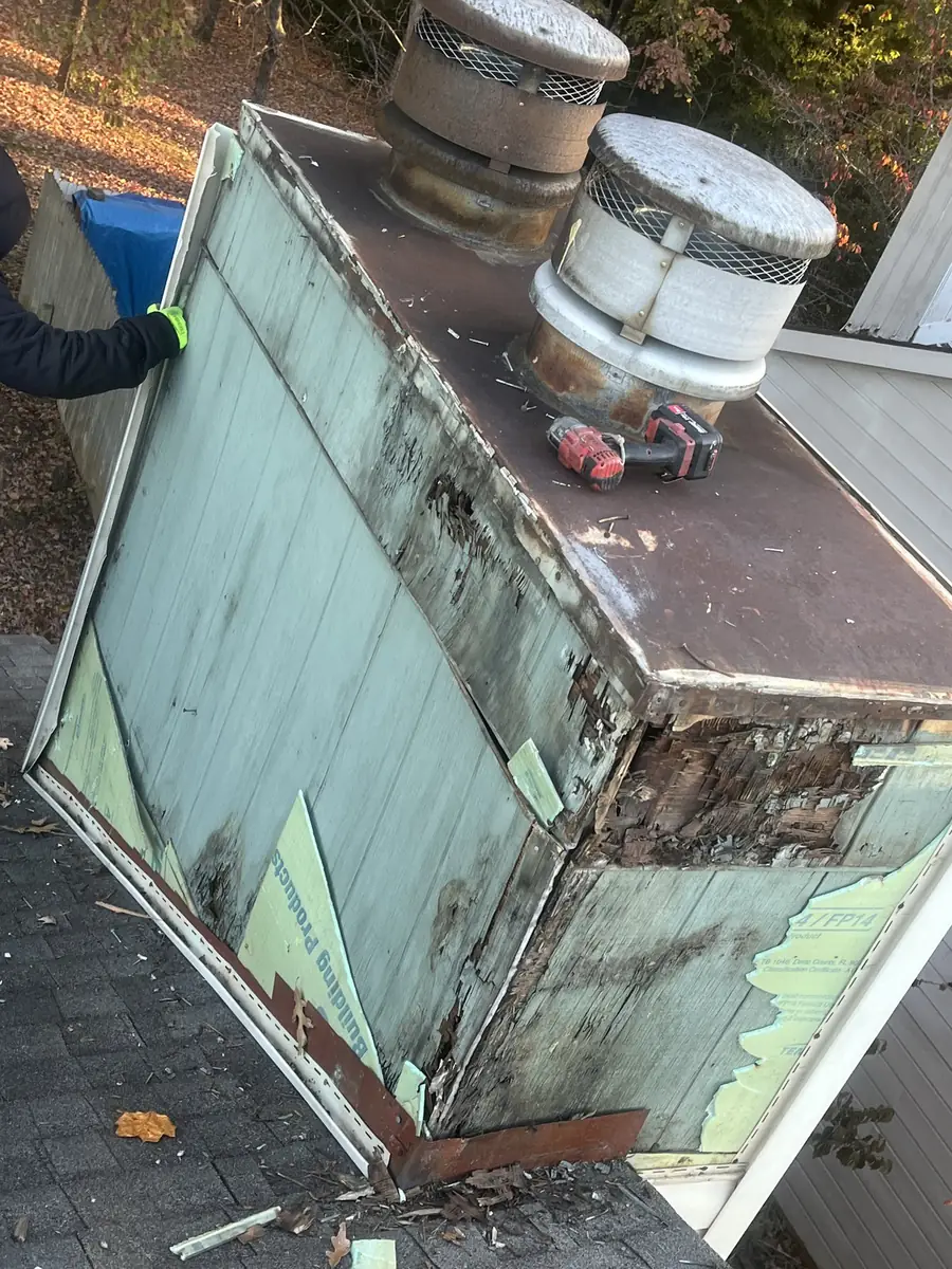 Damaged metal around a chimney cricket, with old flashing pulled back