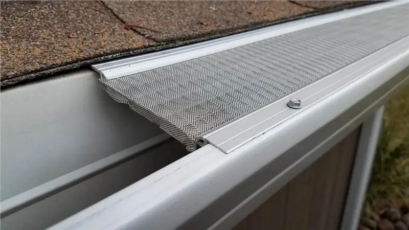A close view of a metal gutter guard over a white gutter