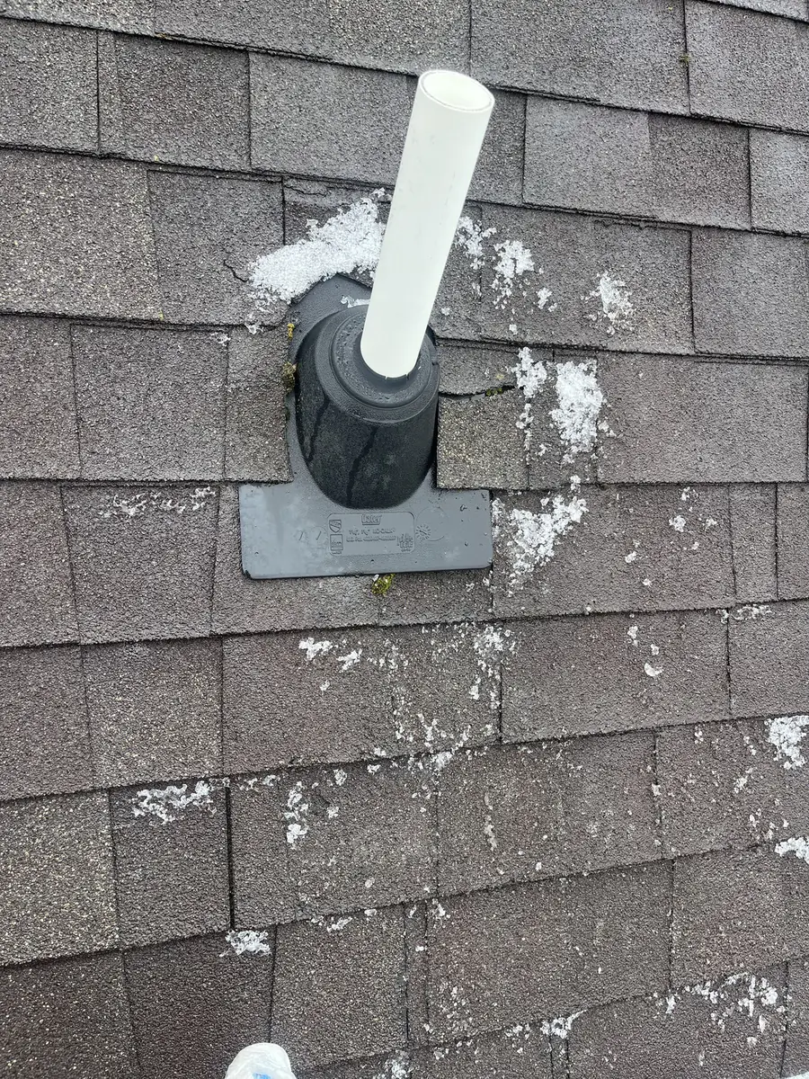 A cracked old pipe boot on worn shingles