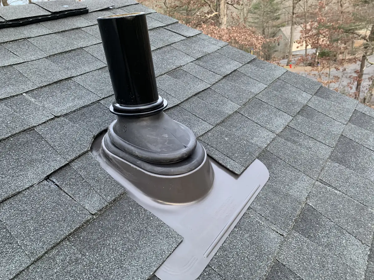 A new pipe boot around a black vent pipe on gray shingles