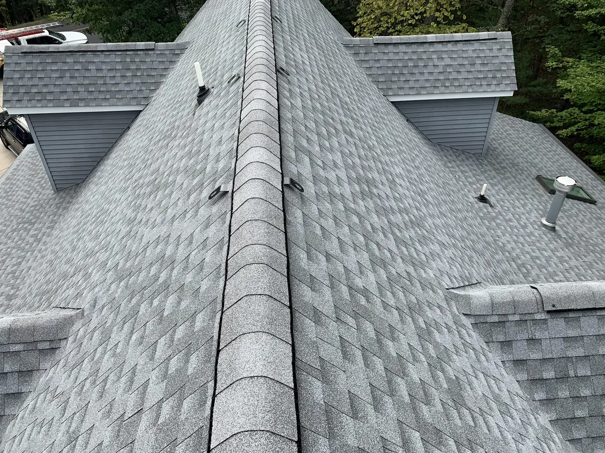 A gray shingle roof with a ridge line and two dormers