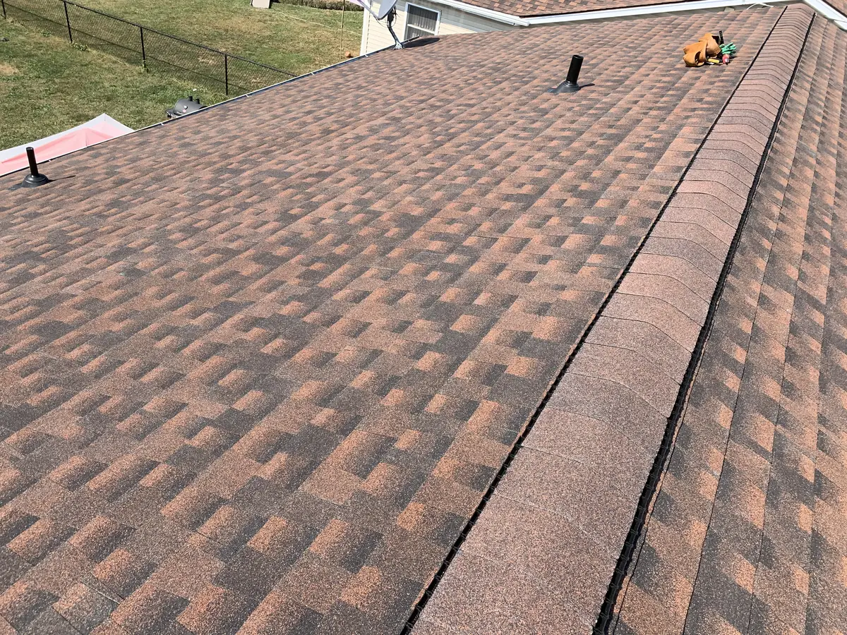 A new brown architectural shingle roof with a ridge cap