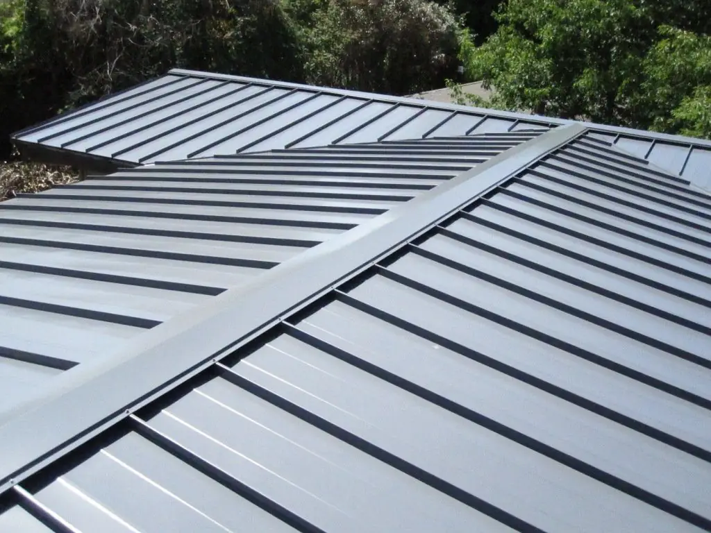 Gray standing-seam panels meeting at a roof valley