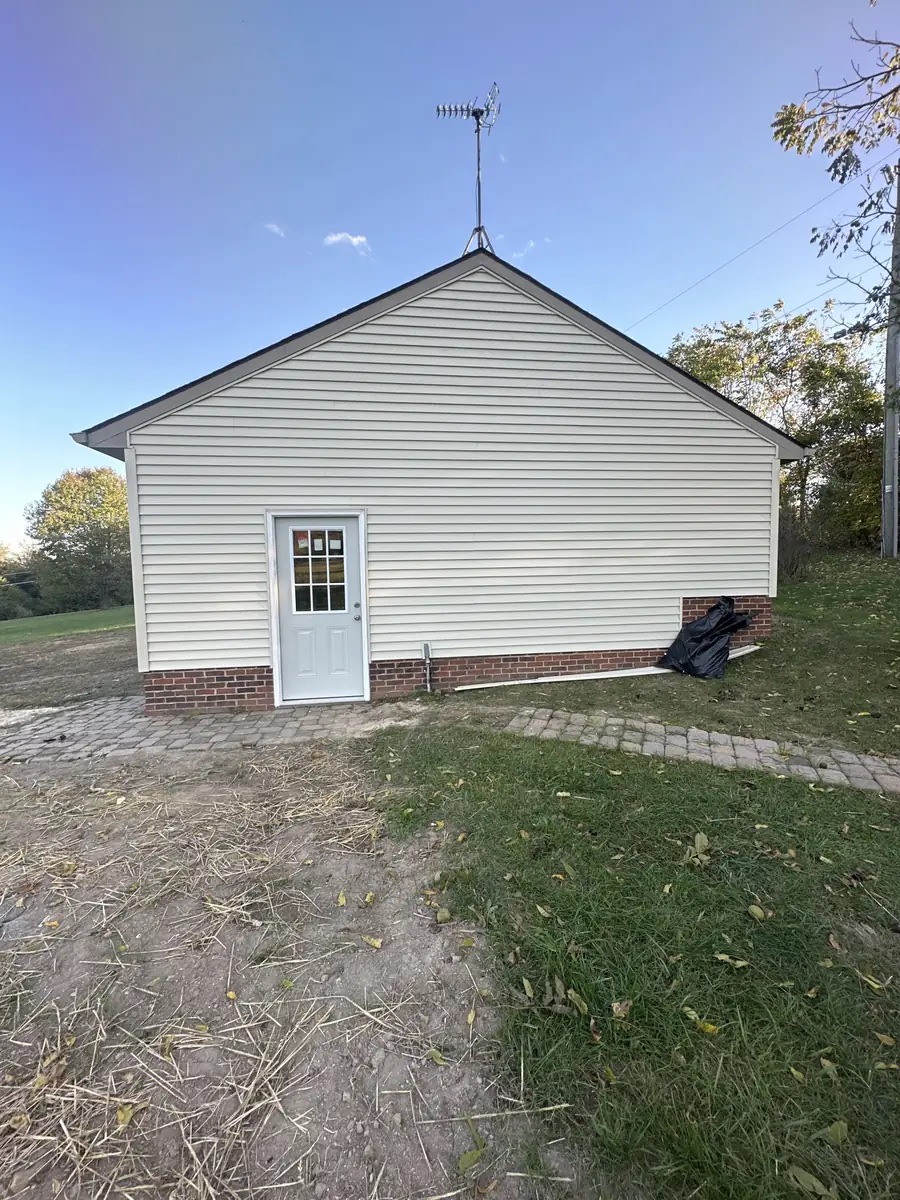 A small building with new white lap siding