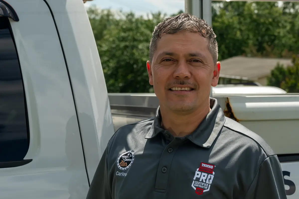 Portrait of Carlos Sagastume beside a work truck